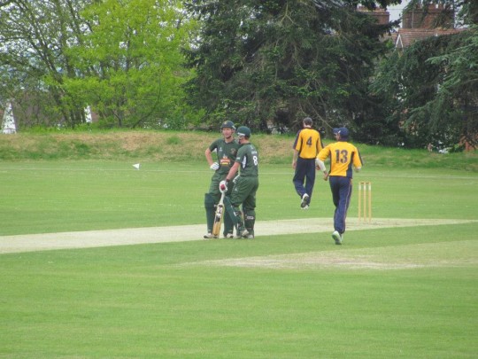 Two batsmen having a chat, probably about what they will be eating at Tea