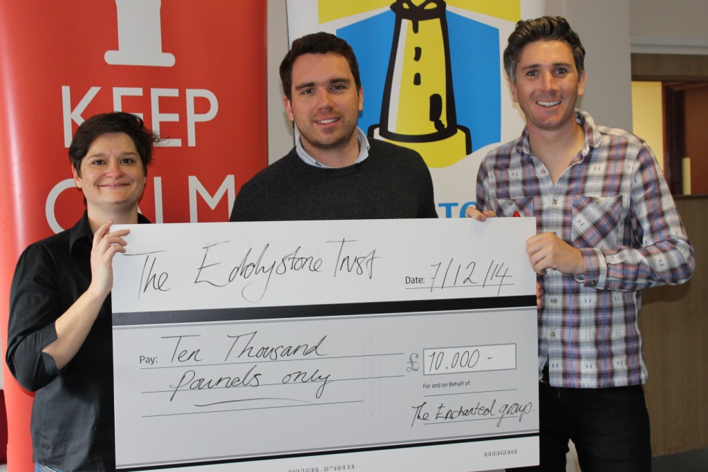 Sarah Aston from the Eddystone Trust receives a cheque for £10,000 from Tom Wye and Sam King of The Enchanted Group