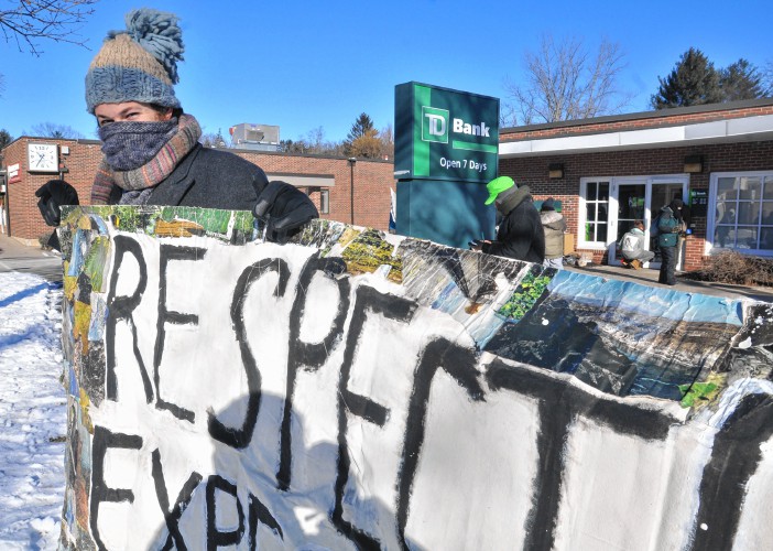 Adam Bothamley protesting the TD Bank's involvement in the Dakota Pipe line. (photo from the Daily Hampshire Gazette)