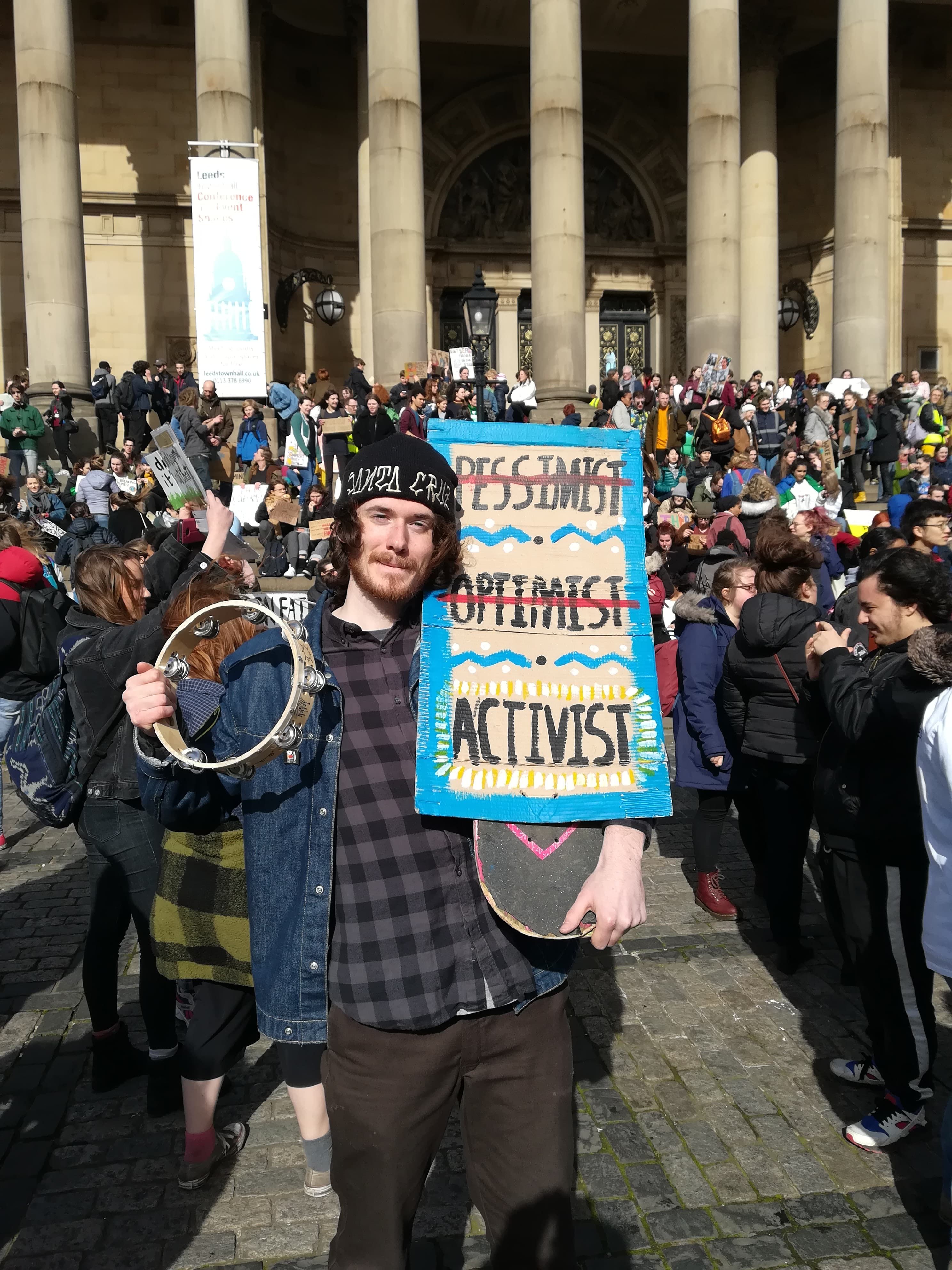 Image may contain: Banner, Parade, Musical Instrument, Musician, Festival, Text, Crowd, Clothing, Shoe, Apparel, Footwear, Person, Human