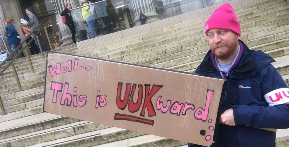 Image may contain: Cap, Hat, Apparel, Clothing, Banner, Text, Human, Person