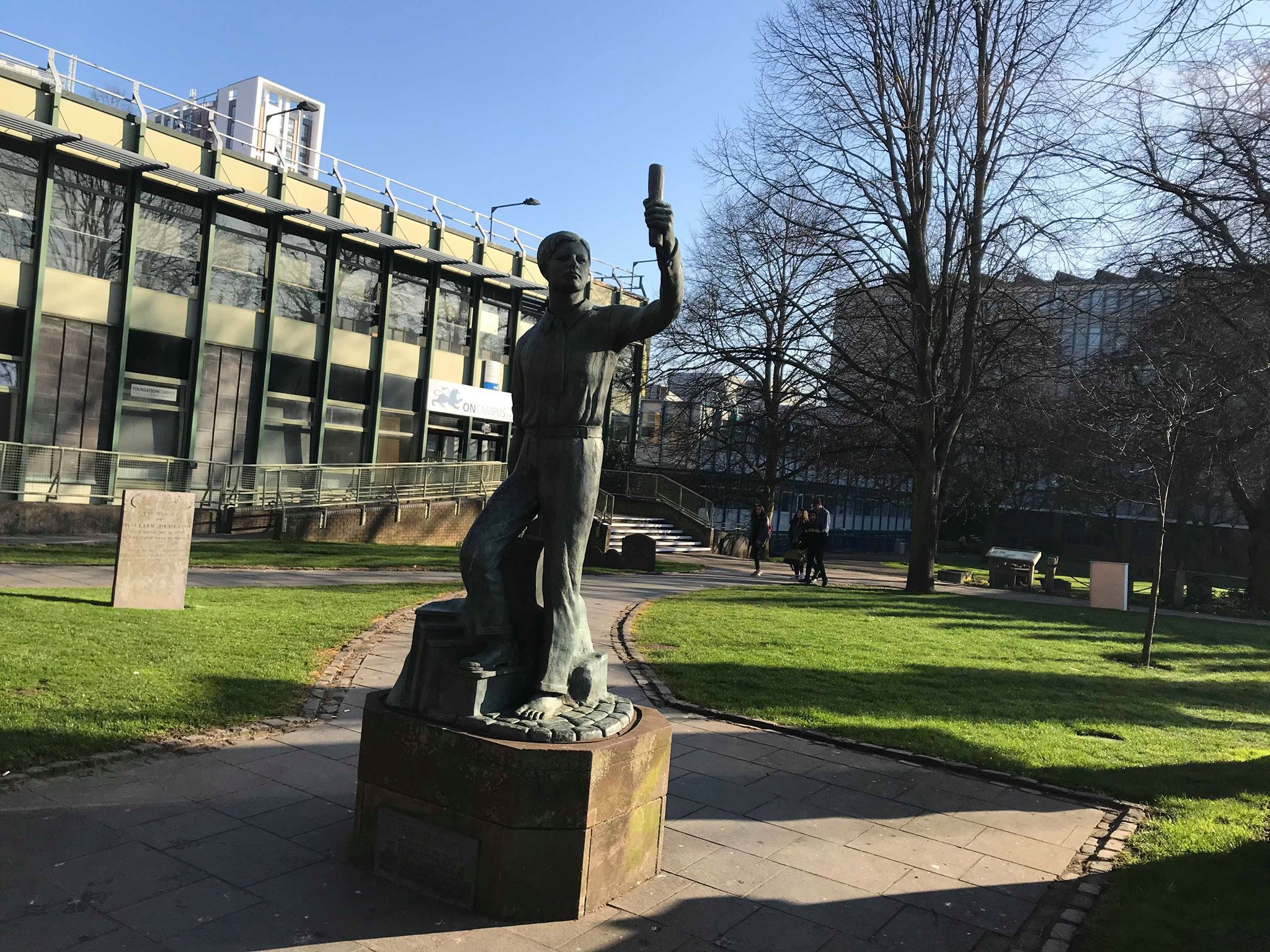 Image may contain: Flagstone, Campus, Architecture, Monument, Plant, Grass, Sculpture, Art, Statue, Building, Town, Urban, City, Downtown, Human, Person