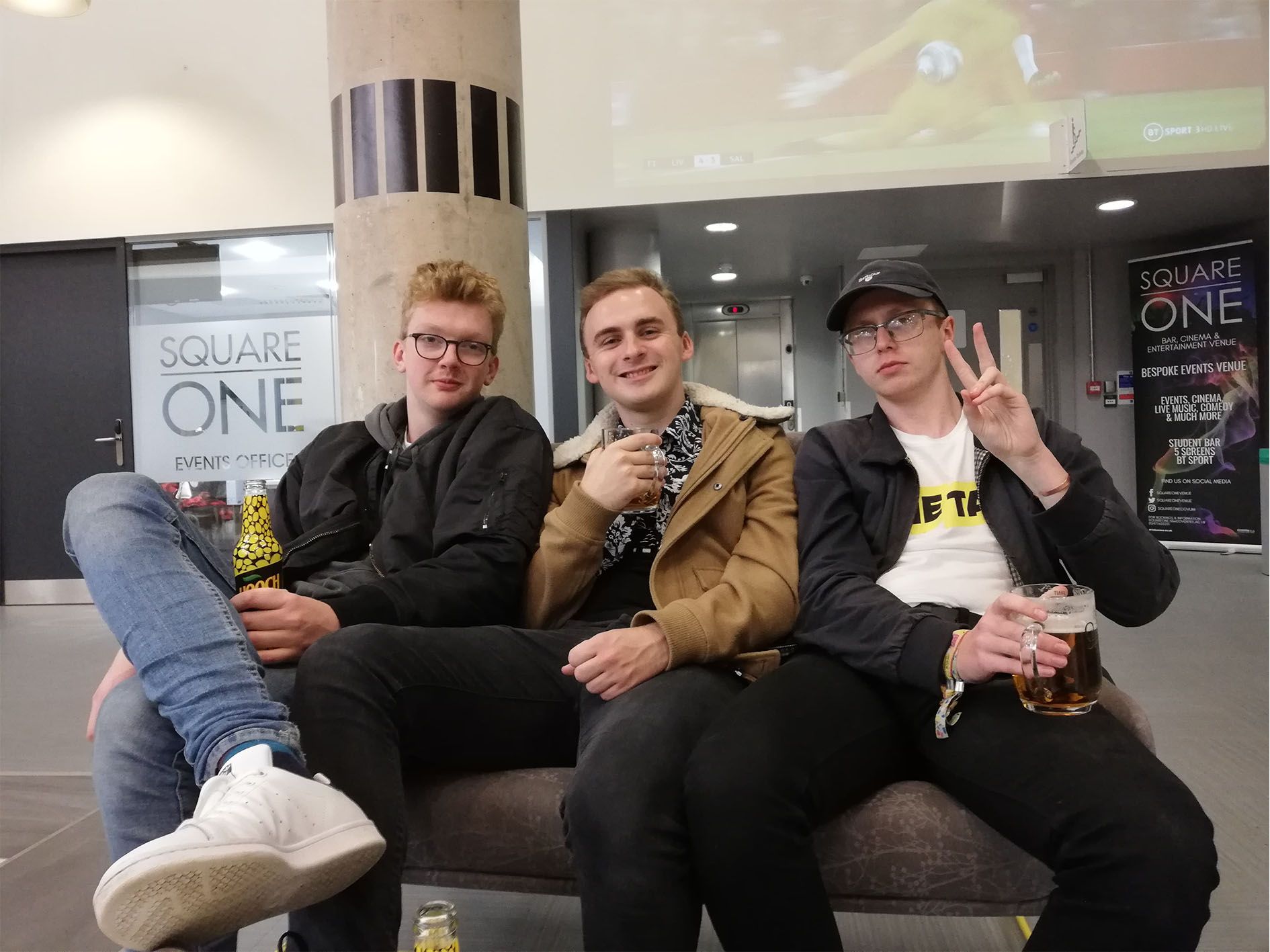 Image may contain: Glass, Indoors, Room, Waiting Room, Pants, Crowd, Furniture, Couch, Shoe, Clothing, Apparel, Footwear, Sitting, Person, Human