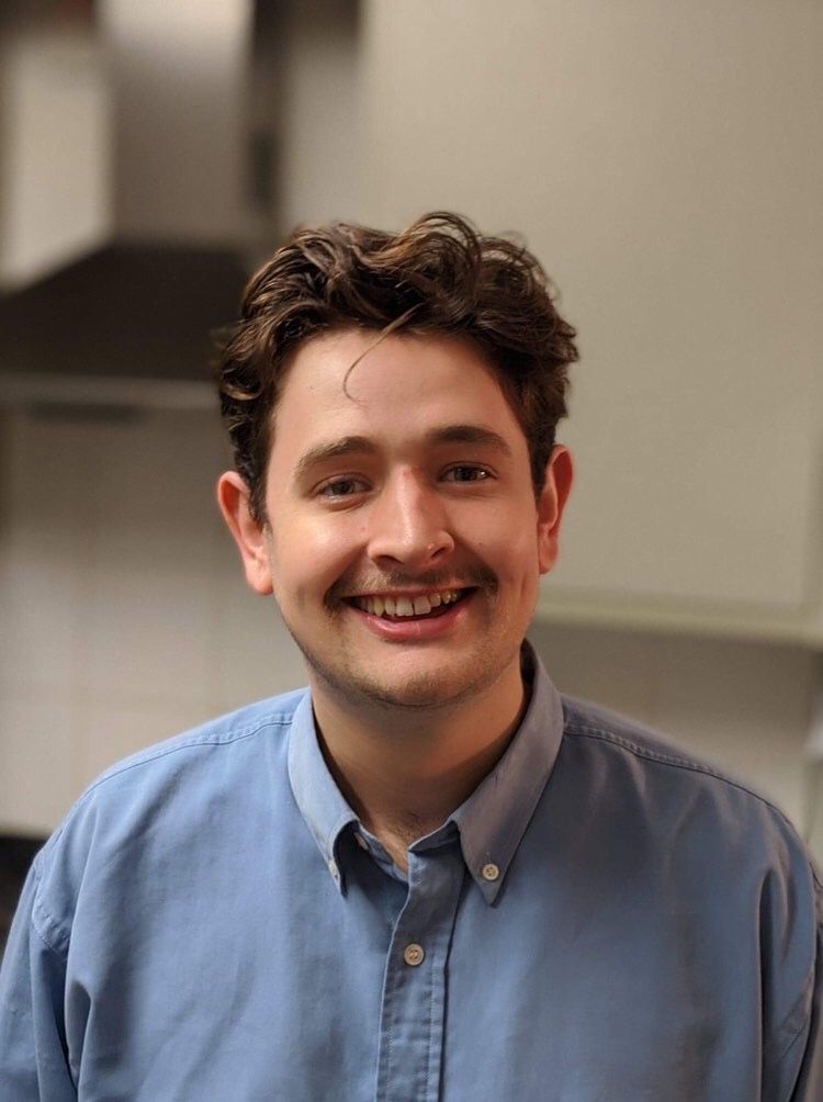 Image may contain: Shelf, Smile, Man, Face, Clothing, Shirt, Apparel, Human, Person