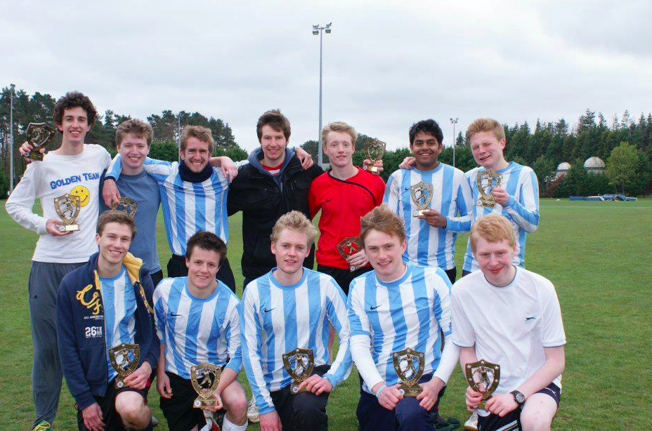 A soccer team in blue and white stripes pose for a photo