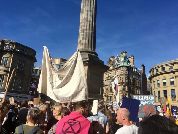 Crowds with banners outside Monument protesting the climate crisis and government inaction.