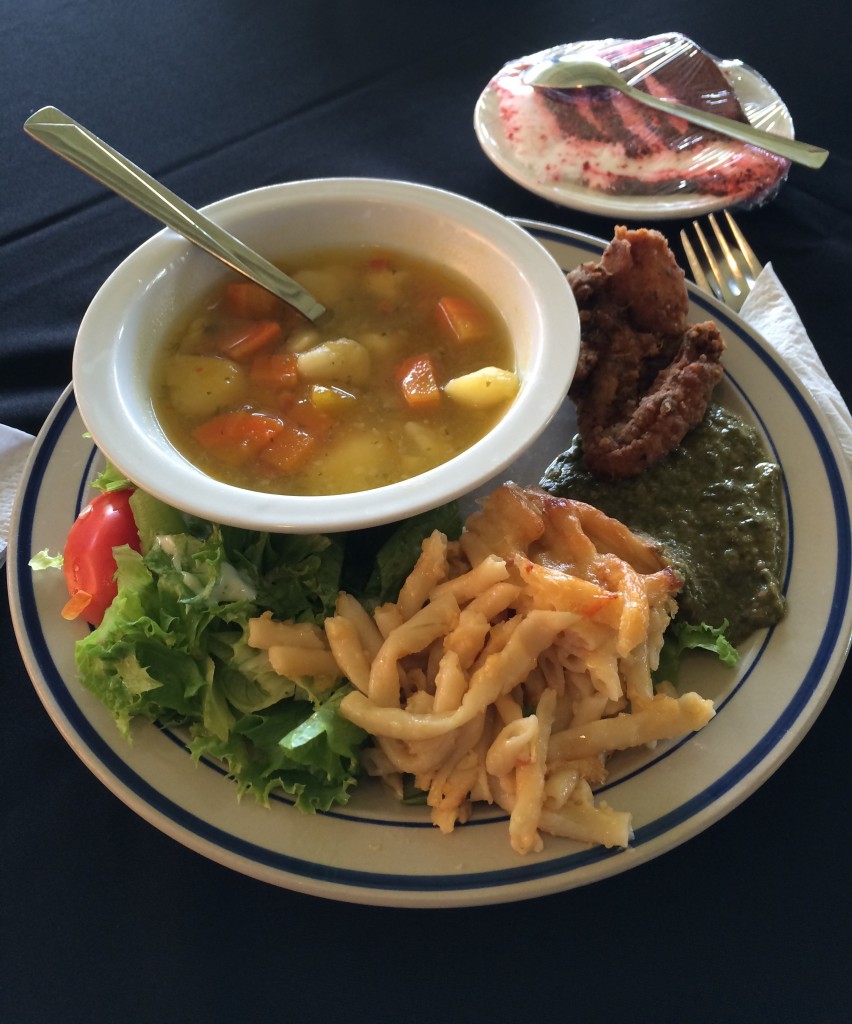 A plate of some popular Trini dishes: hearty soup, macaroni pie and callaloo - a mushy blend of green vegetables
