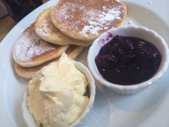 Yummy pancakes with whipped cream and fruit compote