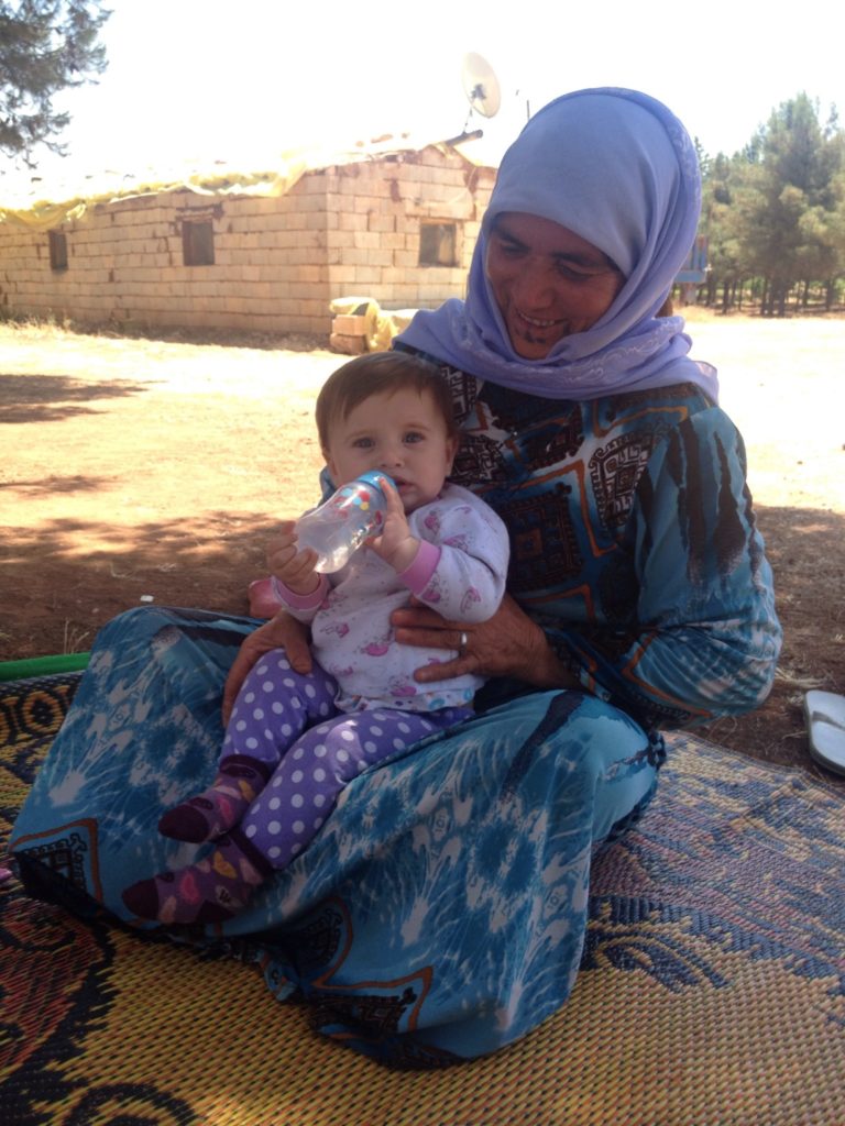 A Kurdish Syrian woman with her grandchild.