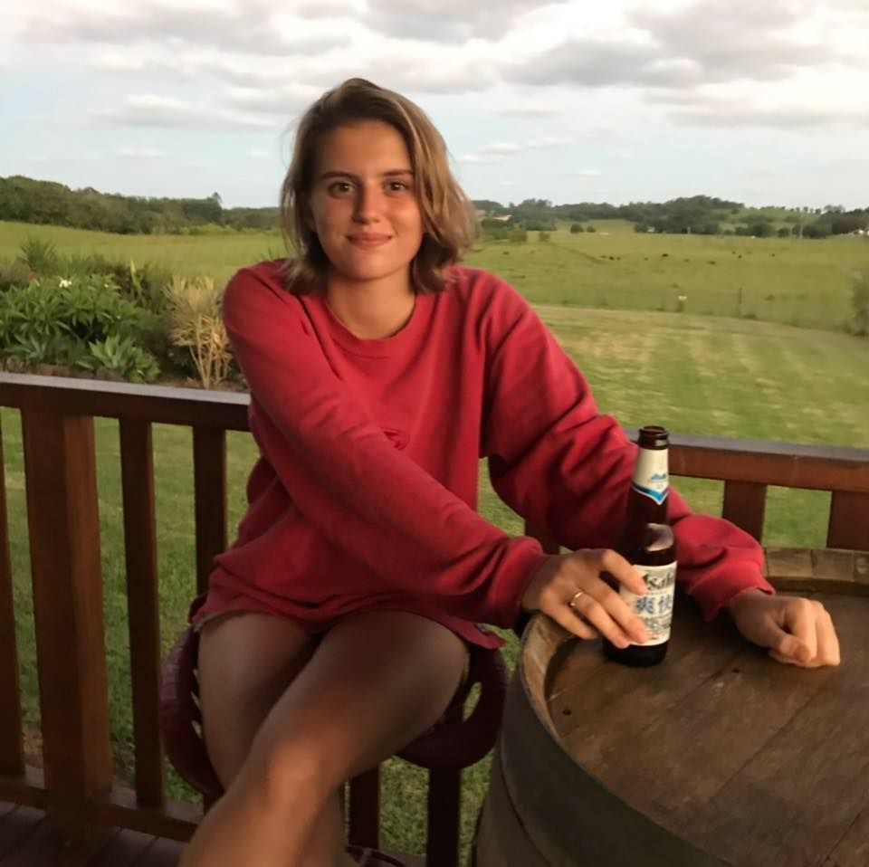 Image may contain: Female, Table, Beer Bottle, Grass, Plant, Chair, Bottle, Apparel, Clothing, Furniture, Human, Person, Drink, Beverage, Alcohol, Beer