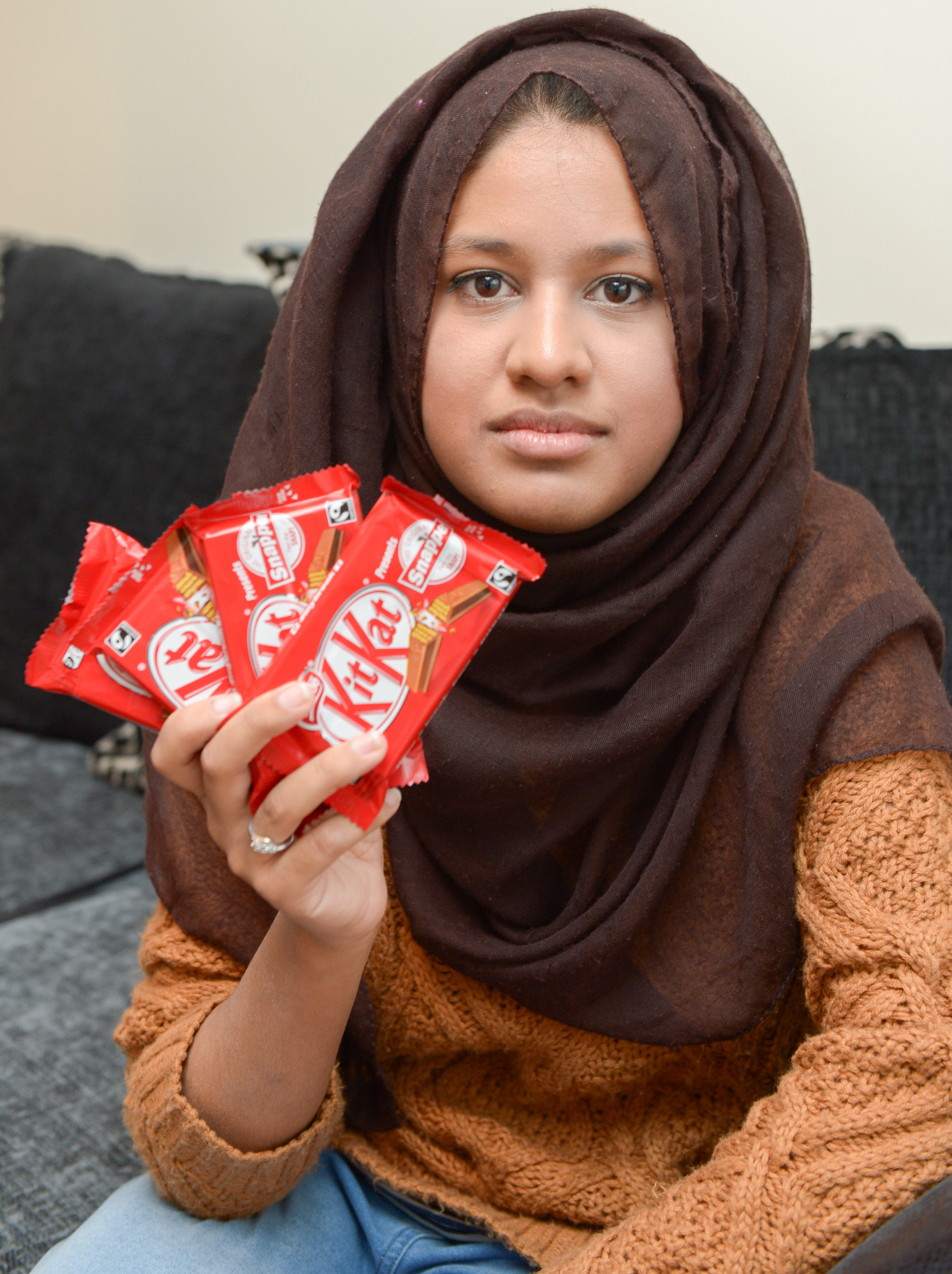 Saima Ahmad holding four KitKats, Saima is so furious she has demanded a lifetime supply of KitKat bars and threatened legal action against Nestlé after she discovered that some of the chocolate fingers in her multipack contained no wafer and were just pure chocolate. Enfield, London See SWNS story SWKITKAT; A furious woman is demanding a lifetime supply of chocolate under threat of legal action - after getting eight KitKats with no WAFER. Saima Ahmad (corr) was so enraged that she wrote a strongly worded letter to manufacturer Nestle explaining her disappointment and even quoted case law from the 1930s to back up her case. The 20-year-old law student from Enfield, north London, bought a multipack of eight KitKat from her local supermarket for £2 last month to share with her friends. Whinging Saima, a second year law student at Kings College London, feels misled by the company and believes that they have ignored their duty of care to consumers. The massive complainer said: "They go about advertising the unique concept of KitKat, but I'm so disappointed by what I have purchased.