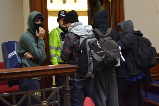 Occupiers cover their faces from the bitter cold of the senate chamber.
