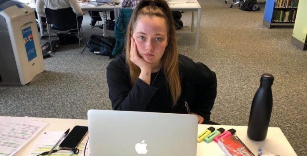 Image may contain: Female, Dining Table, Chair, Desk, Face, Table, Laptop, Furniture, Computer, Electronics, Pc, Human, Person