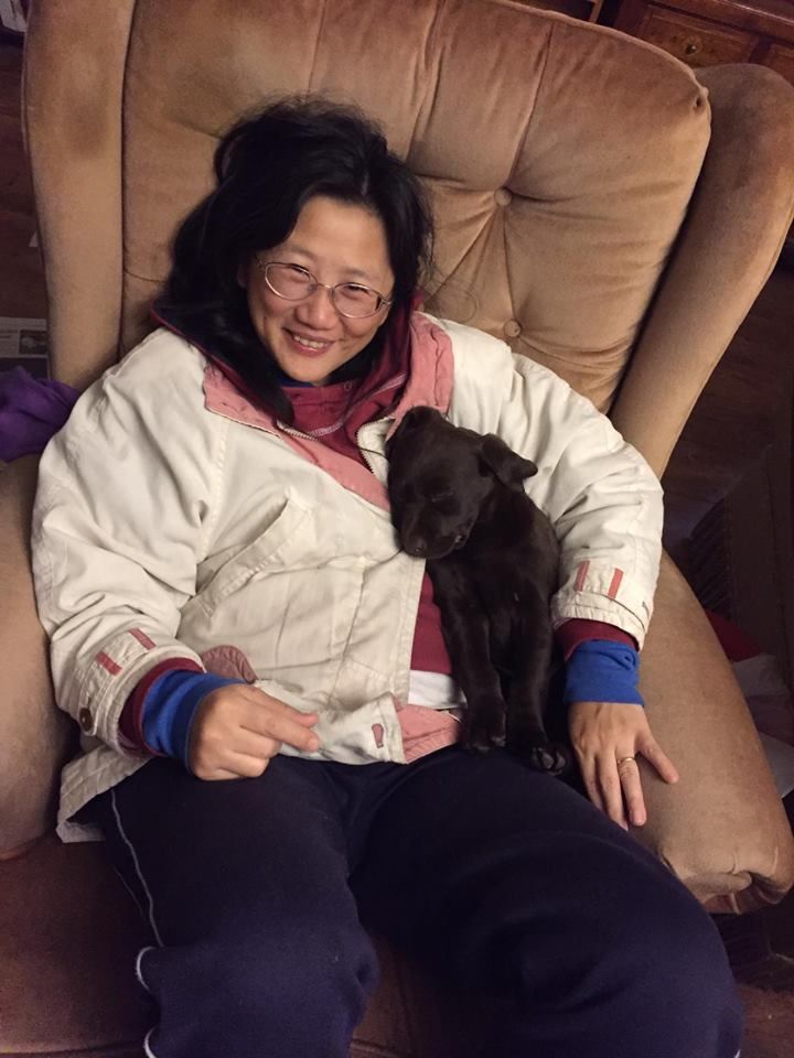 Image may contain: Bed, Female, Clothing, Apparel, Face, Dog, Puppy, Pet, Mammal, Animal, Canine, Human, Person, Cushion, Pillow, Furniture, Couch