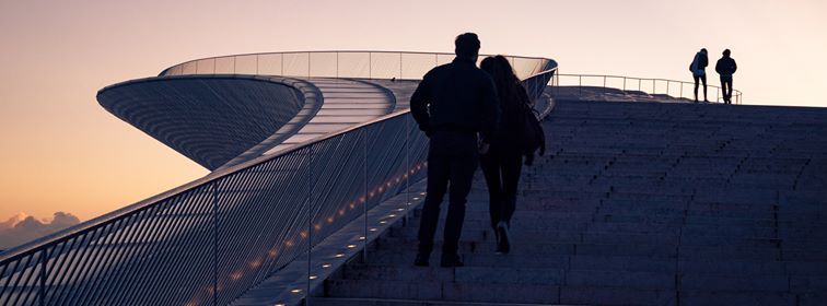 Image may contain: Pedestrian, Outdoors, Building, Lighting, Silhouette, Person, Human