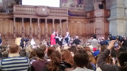 Malala raises her arm in celebration as she receives her Honorary Degree