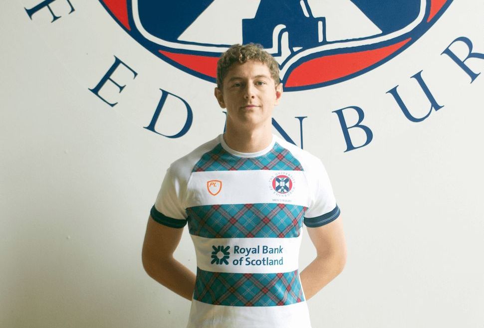 Image may contain: Text, Trademark, Symbol, Logo, Jersey, T-Shirt, Shirt, Person, Human, Apparel, Clothing