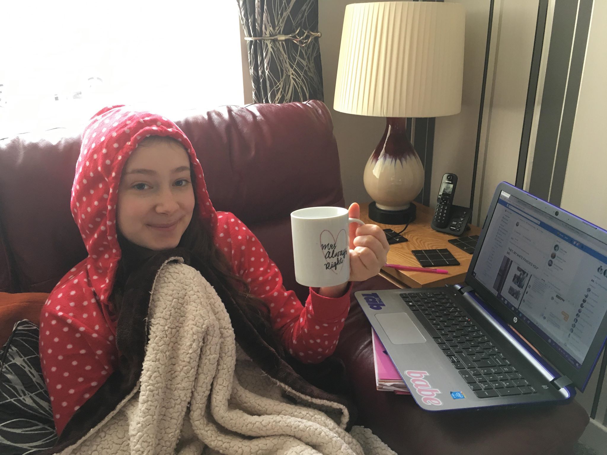 Image may contain: Home Decor, Blanket, Lampshade, Lamp, Pc, Laptop, Electronics, Computer, Person, People, Human, Cup