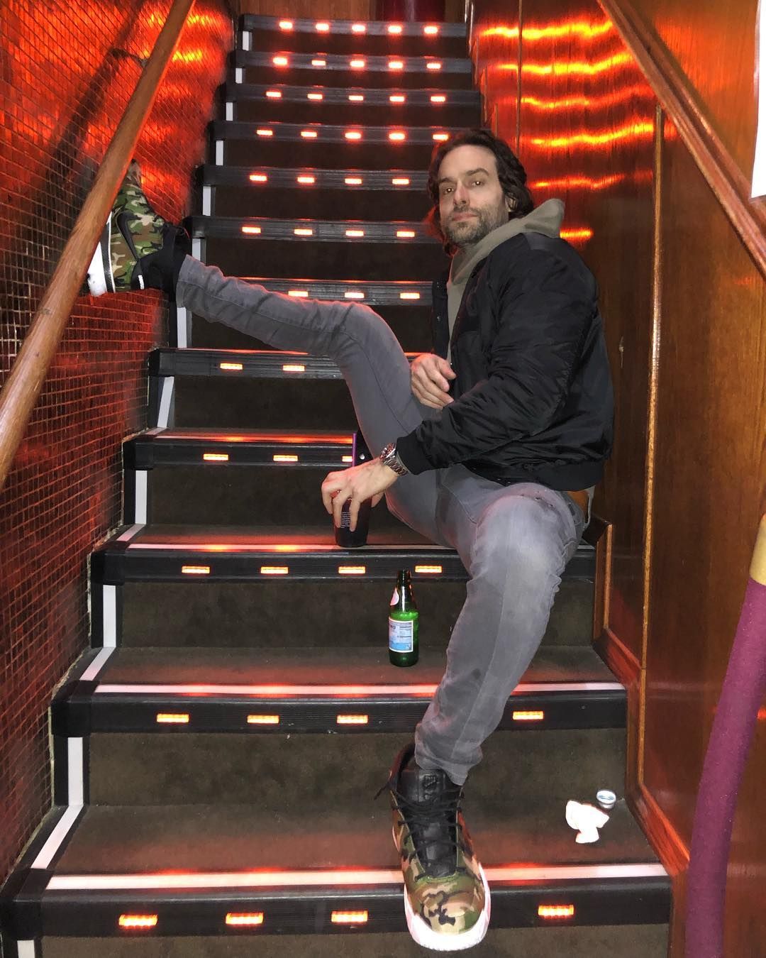 Image may contain: You season 2 cast, cast list, You, Netflix, season 2, Chris D'Elia, Henderson, Boot, Staircase, Human, Person, Banister, Handrail, Shoe, Apparel, Footwear, Clothing