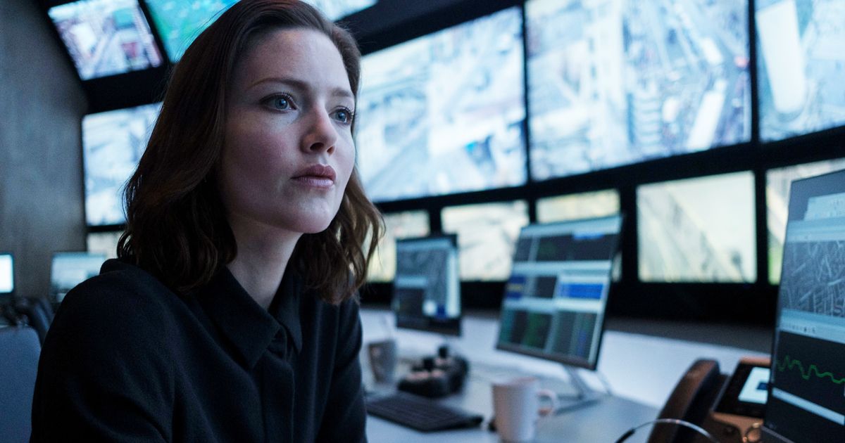 Image may contain: The Capture cast, The Capture, BBC, One, Holliday Grainger, Rachel Carey, Computer, Pc, Laptop, Desk, Furniture, Table, LCD Screen, Monitor, Electronics, Display, Screen, Human, Person