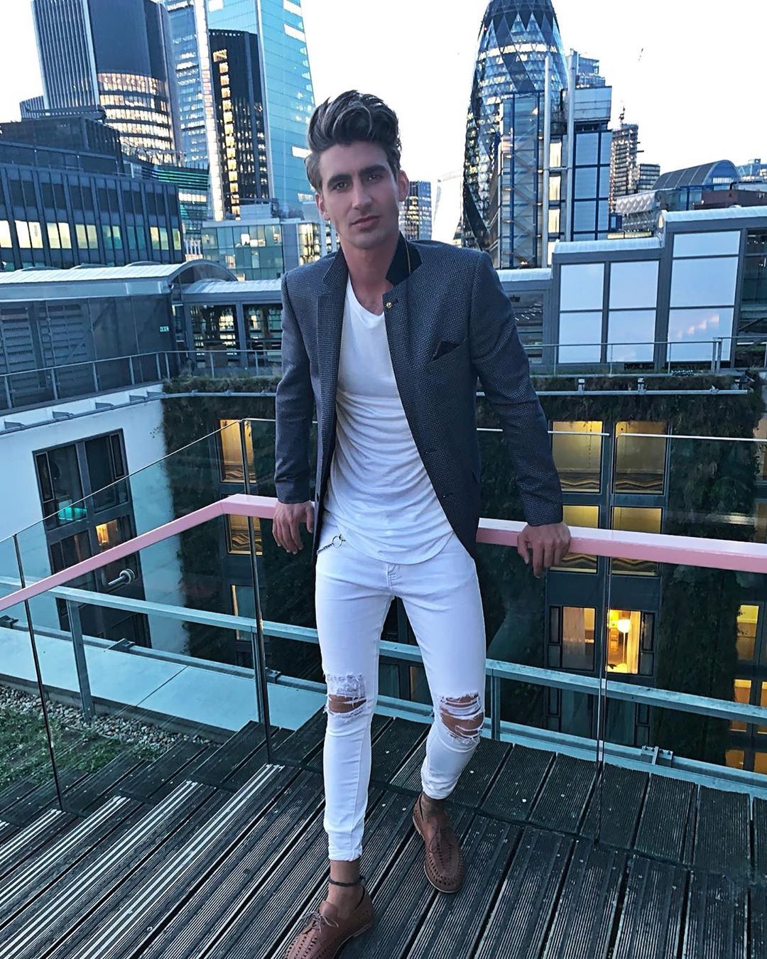 Image may contain: Love Island 2019 contestants, Love Island, 2019, now, job, Instagram, updates, news, latest, series five, Chris Taylor, High Rise, Suit, Overcoat, Metropolis, Town, City, Urban, Building, Person, Human, Coat, Blazer, Jacket, Apparel, Clothing
