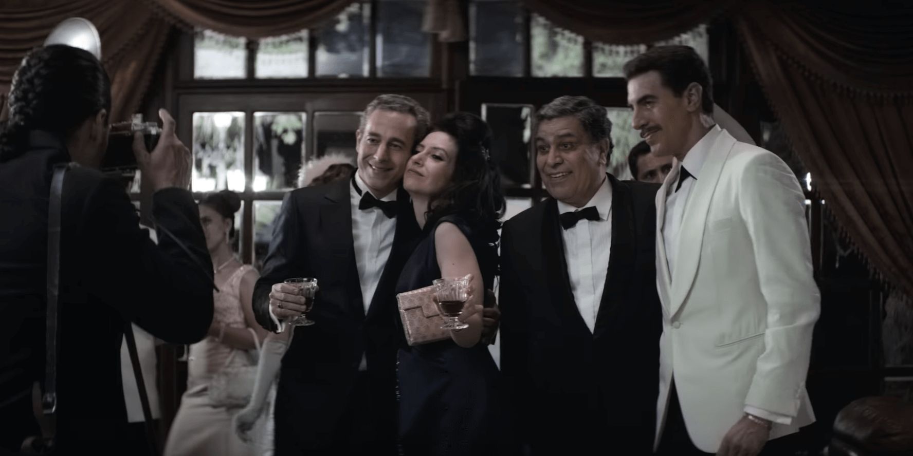 Image may contain: The Spy, Netflix, Sacha Baron Cohen, Eli Cohen, spy, real life, true story, events, trailer, Mossad, intelligence, Syria, Israel, espionage, death, Kamal Amin Thabet, People, Evening Dress, Robe, Gown, Fashion, Shirt, Tuxedo, Suit, Overcoat, Coat, Clothing, Apparel, Accessory, Tie, Accessories, Person, Human