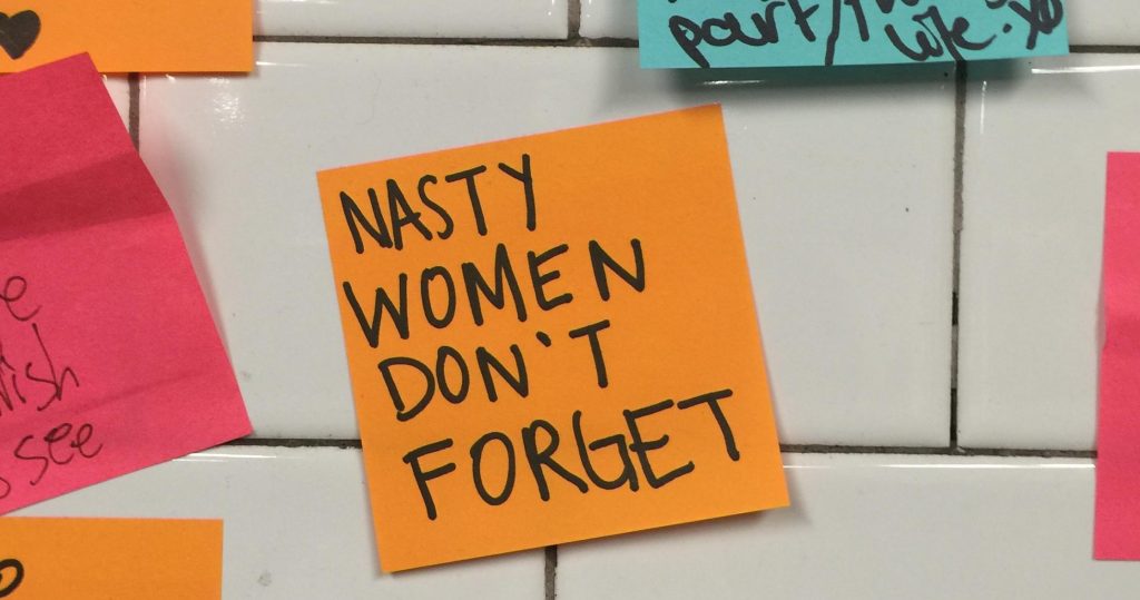 Nasty women dont forget - a post it note on the new york subway