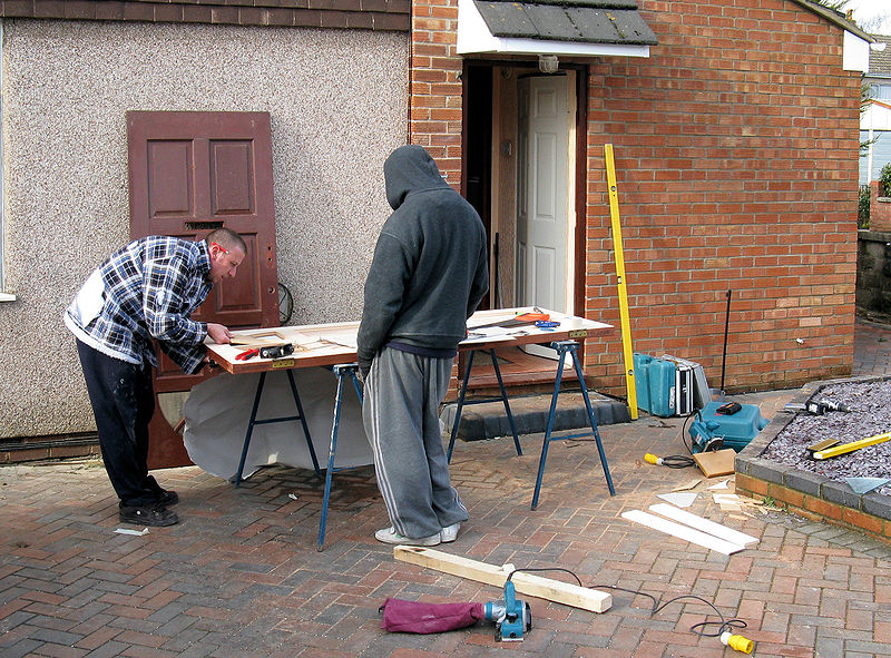 800px-Carpenters_repair_a_door_arp