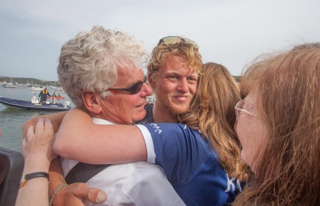 Tom Rainey is hugged as he steps back onto dry land