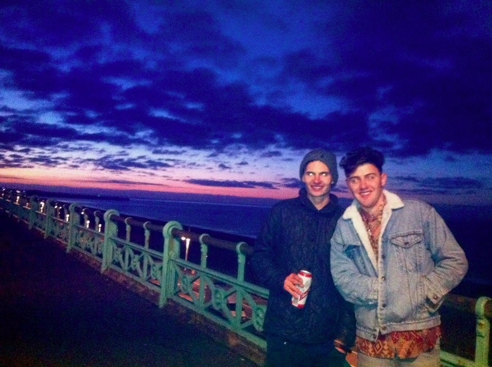brighton palace pier two male friends drinking beer